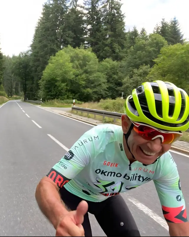 Ronald Dähne mit Radhelm auf dem Rennrad, Daumen hoch
